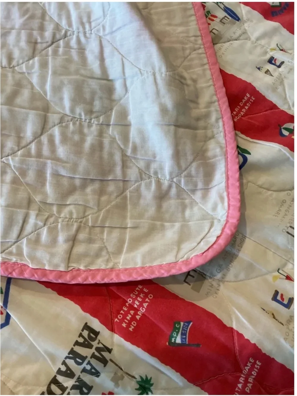 Vintage Marine Paradise quilted blanket featuring a colorful red and cream novel